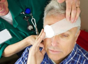 Paramedic nurse attending to a patient's eye after injury- eye bandaged