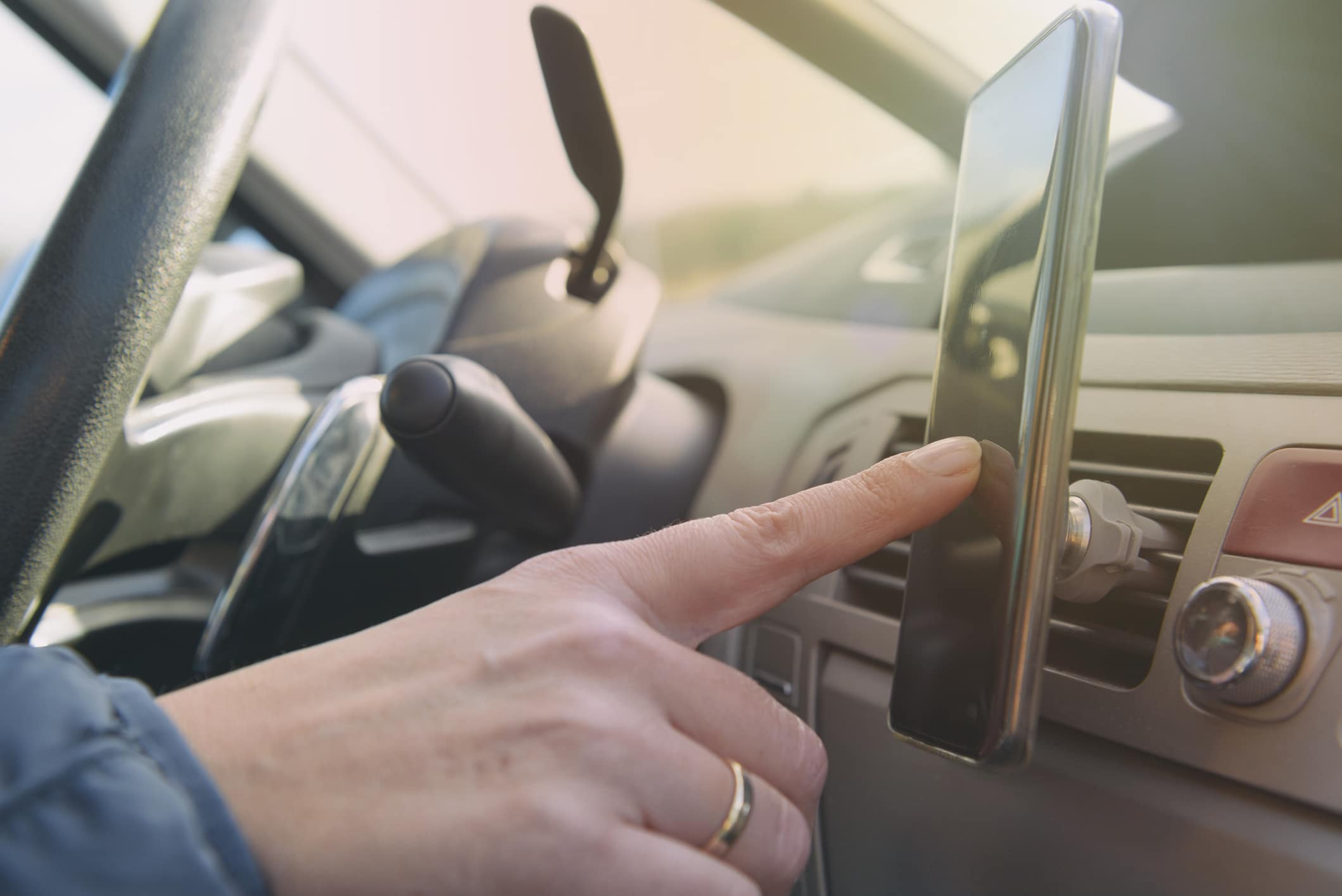 A person touching their phone while driving.