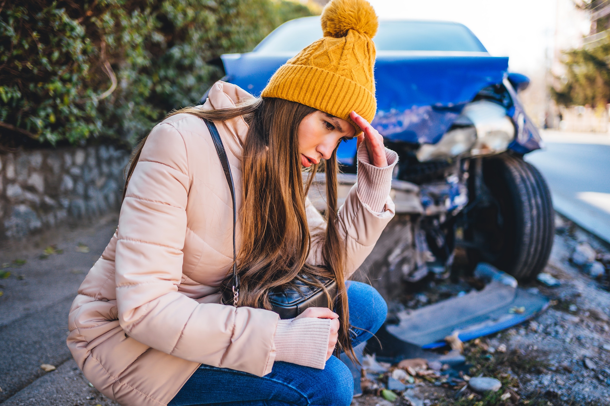 A young woman feeling worried after getting into a car accident.