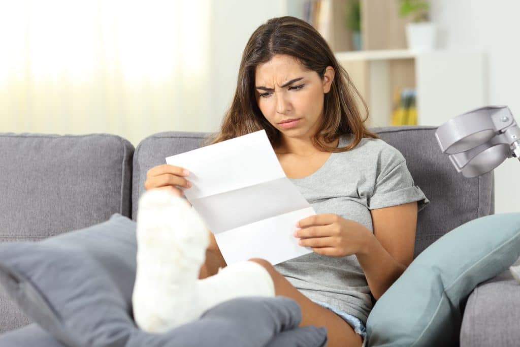 An Austin, TX, woman reading her medical bills while recovering from a truck accident injury.