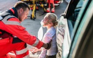 A first responder helping an injured woman after a car accident. 