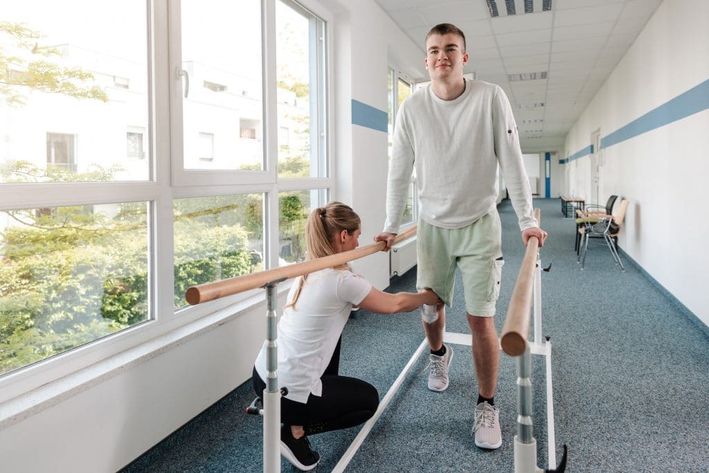 A young man going through physical therapy after an injury.