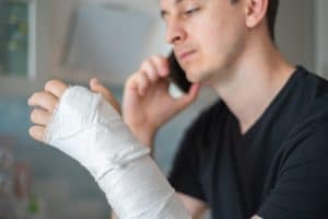 An injured man calling a reputable lawyer after a truck accident. 