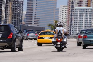 A motorcycle driving in traffic on the highway. 