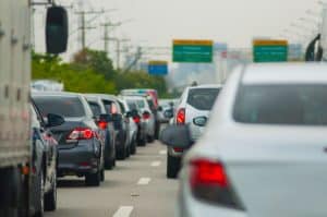 Cars sitting in heavy traffic on the interstate.