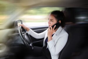 Woman engaged in unsafe behavior, talking on the phone while driving.