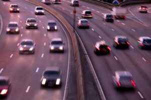 Nighttime scene of cars in motion, captured with artistic motion blur for a dynamic and atmospheric perspective.