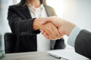 How can I assist? Image of two lawyers warmly shaking hands.