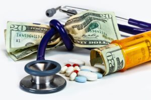 Symbolic image: Stethoscope knotted around a fistful of money, illustrating financial aspects in healthcare or medical cost challenges.