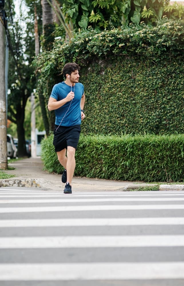 Young man running across the road.