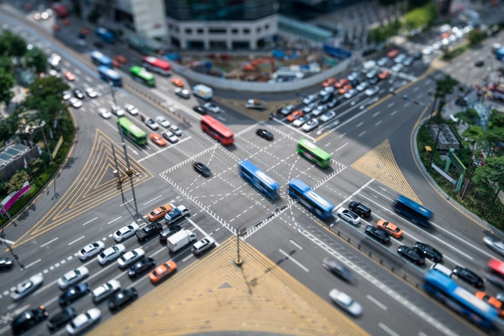 Aerial view of a busy urban intersection with heavy traffic, illustrating the risk of multi-vehicle crashes during rush hour.