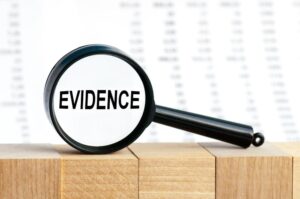 Word 'Evidence' viewed through a magnifying glass.