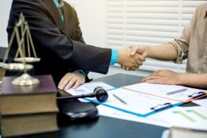 A client shaking hands to seal a deal with his car accident lawyer discussing a accident case