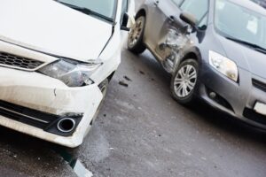 Street car crash scene with damaged automobiles after collision in urban area.