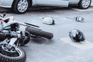 Car mirror, headlight, helmet, and motorcycle on the road after a collision in San Antonio.