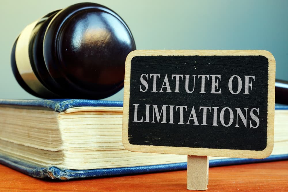 Gavel resting on legal book beside sign reading 'Statute of Limitations