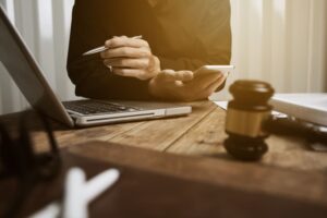 Lawyer working on a case with laptop, gavel in foreground, focused.