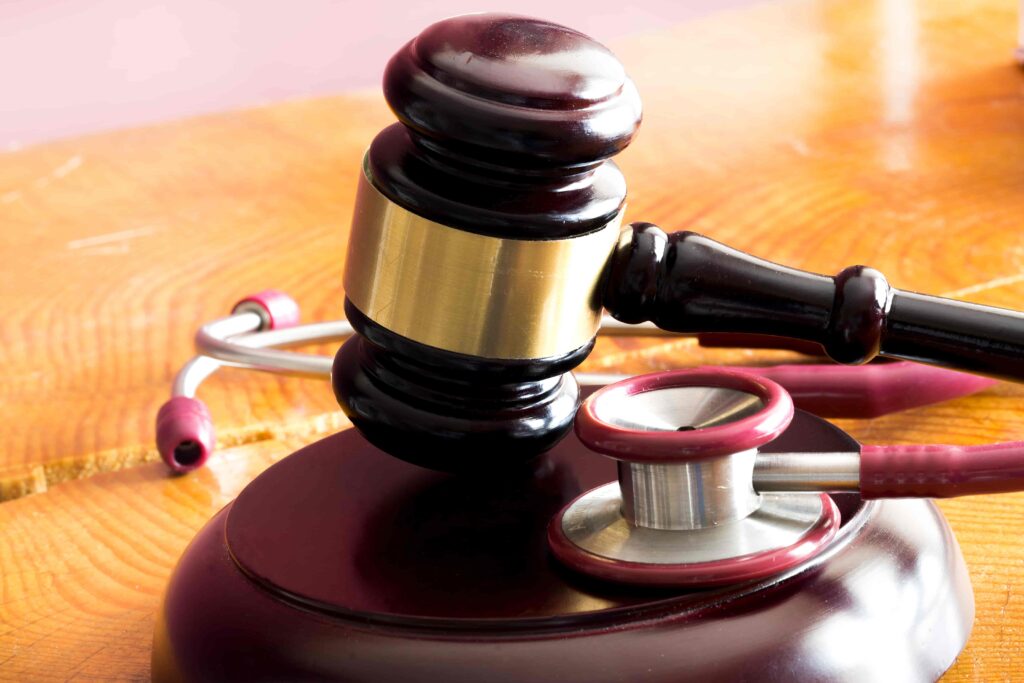 Judge’s gavel and stethoscope on wooden table symbolizing medical malpractice and healthcare liability law.