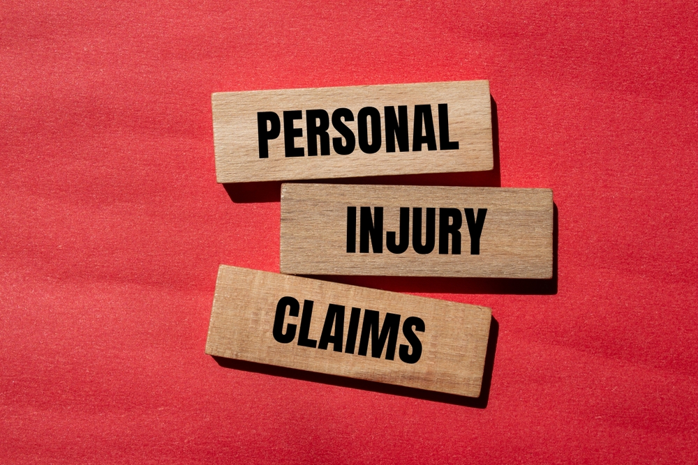 Personal injury claims written on wooden blocks with red background. Conceptual personal injury claims symbol. Copy space.